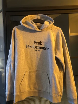 Äkta peak performance - Äkta märkes hoodie knappt använd. Grå och bekväm o varm att ha på sig. Hoodien är strl L men passar även M och S. Nypris ca 1300