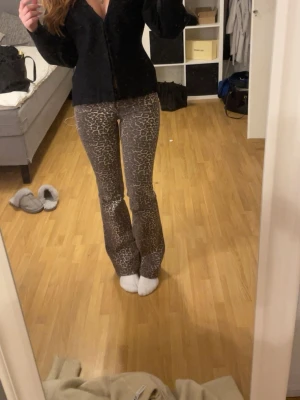 Leopardmönstrade bootcut byxor - Säljer ett par snygga bootcut byxor med leopardmönster. Byxorna har en figurnära passform upptill och utsvängda ben. Perfekta för dig som vill sticka ut med ett djurmönster. Materialet känns mjukt och stretchigt.