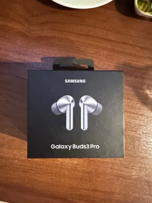 Galaxy Buds3 Pro - Samsung Galaxy Buds3 Pro trådlösa hörlurar i silver med laddningsetui. Snygg design, aktiv brusreducering och lång batteritid. Produkten ser ut att vara i mycket gott skick och levereras komplett med originalförpackning, laddkabel och manual.