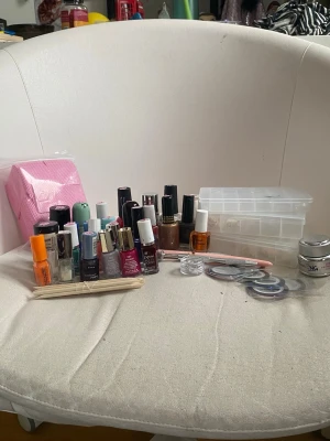 Stort nagelkit med lack och tillbehör - Säljer ett nagelkit med flera nagellack och även några gellack i olika färger. Vissa har inte så mycket kvar. Inkluderar även nagelverktyg, nagelbandspinnar, dekorationsband, en burk med primer, penslar, tre lådor med tippar (ej fulla) och rosa wipes. Perfekt för dig som vill fixa naglarna hemma.