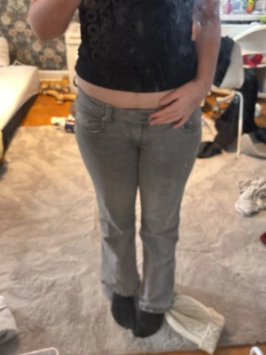 Grå jeansbyxor med broderad ficka - Säljer ett par grå jeansbyxor från 157 i storlek M Short. Byxorna har ett snyggt broderat mönster på bakfickan och klassisk femficksmodell. Materialet är mjukt jeans och passformen är rak med något utsvängda ben.