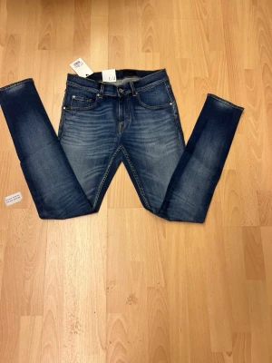 Tiger of Sweden slimmade  jeans  W30 L32 - Säljer ett par snygga blå jeans från Tiger of Sweden med slim passform och smal fot. Klassisk femficksmodell med orange sömmar och läderpatch bak i midjan. Perfekt tvättad look och riktigt schysst färg.