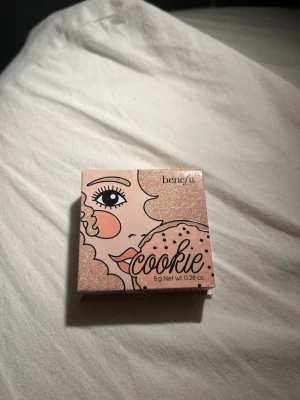 Benefit Cookie Highlighter 8g - Supersnygg highlighter från Benefit i nyansen Cookie. Ger ett mjukt guldigt skimmer som passar perfekt för att framhäva kindbenen. Innehåller 8g produkt. Helt oanvänd (se bild 3)💞 Ordinarie pris 385kr!