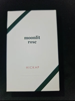 Moonlit Rose parfym från Hickap - Doften bjuder på en elegant, blommigt-orientalisk signatur där frisk jasmin, ros och en hint av vanilj möter cederträ i toppen. I hjärtat sveper sammetslent sandelträ in, tillsammans med mjuk musk och kanderad frukt. Doften rundas av i freesia, liljekonvalj och djup patchouli för ett sofistikerat, långvarigt och personligt avtryck.