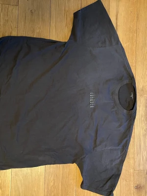 Svart t-shirt från YoungLA - Svart t-shirt från YoungLA med liten vit logga tryckt på bröstet. Klassisk rund halsringning och korta ärmar. Perfekt för en stilren och enkel look. Originalpris: 450 kr