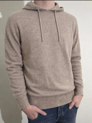 Kaschmir/Merinoull Hoodie - Exklusiv och stilren hoodie i Kaschmir/Merinoull ✨ Perfekt för vår- och sommarsäsongen. Storlek S, mycket sparsamt använd (max 3 gånger) och i utmärkt skick utan defekter. Kontakta mig gärna vid intresse eller frågor 😊