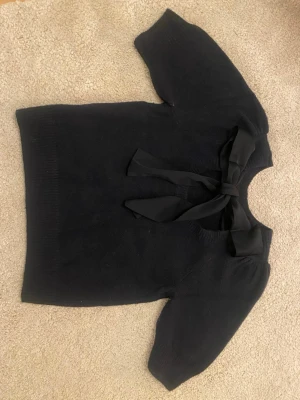 Blå stickad tröja med rosett - Jätte gullig stickad tröja med rosett från neonoir. Passar bra om man behöver vara lite uppklädd. Marin blå och storlek 34 så typ S eller XS