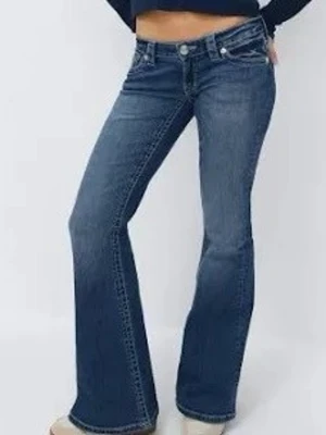 Blå bootcut jeans med låg midja - Snygga blå bootcut jeans med låg midja och klassisk femficksdesign. Jeansen har en lätt tvättad look och är perfekta för en avslappnad stil. Tillverkade i jeansmaterial med en bekväm passform.