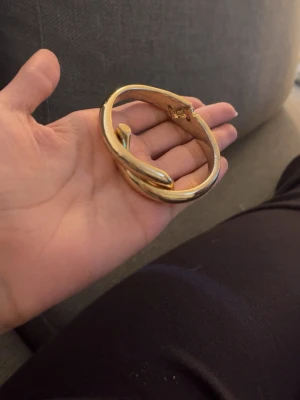 Guldigt armband i spikdesign - Snyggt armband i guldfärgad metall med unik spikformad design. Armbandet har en stilren och modern look med rundad form och enkel låsmekanism. Perfekt accessoar för dig som gillar statement-smycken och vill sticka ut lite extra.