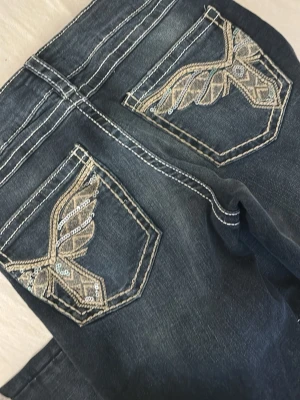 Gina tricot jeans  - Snygga mörkblå jeans från Gina Tricot i modellen Sparkle low flare. Fina broderade detaljer med lite glitter på bakfickorna 🌟 Bekväma och trendiga med utsvängda ben.