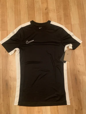 Svart Nike T-shirt  - Säljer denna nya och oanvända med pris lapp kvar. Det är en tränings T-shirt från Nike. Skriv om ni är intresserade eller har frågor
