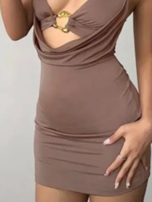 Beige kort klänning med gulddetalj - Trendig beige kortklänning med snygg guldfärgad ringdetalj framtill och draperad urringning. Klänningen har en tight passform och är ärmlös, perfekt för dig som gillar en stilren och modern look.