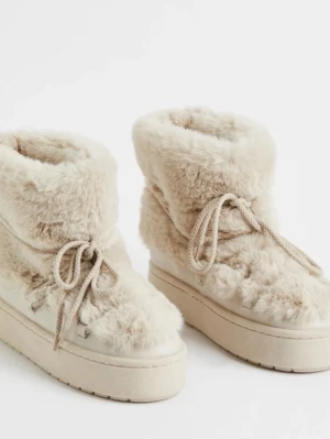 Beige fluffiga moon boots med snörning - Säljer ett par beiga boots med fluffig pälsimitation och snörning framtill från h&m 