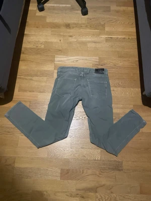Olivgröna Replay Jeans  - Snygga olivgrön jeans från Replay i slim fit-modell. Klassisk femficksdesign med diskret logga på bakfickan. Jeansen är tillverkade i bomull och har en modern, smal passform som passar perfekt till en avslappnad stil. Storlek 30/30.