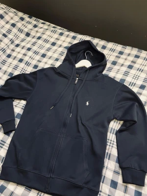 Mörkblå Ralphluaren hoodie - Mörkblå Ralphluaren hoodie i M. Knappt använd priset är inte huggit i sten vid snabb affär.