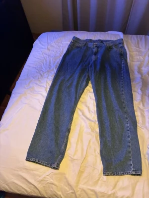 Blå jeans från sweet sktbs - Säljer ett par klassiska blå jeans från sweet sktbs med rak passform och fem fickor. Jeansen har normal midja och är tillverkade i slitstark bomull. Snyggt broderad logga vid fickan och läderpatch baktill. Perfekt för dig som gillar enkel och tidlös stil.