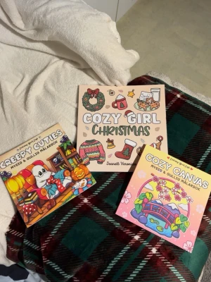 Cozy Girl Christmas, Creepy Cuties, Cozy Canvas - Tre mysiga och gulliga målarböcker med färgglada och charmiga illustrationer. Perfekt för dig som gillar att vara kreativ och koppla av med färgpennor! Passar både ungdomar och unga vuxna som vill skapa egna konstverk och njuta av söta och roliga motiv.