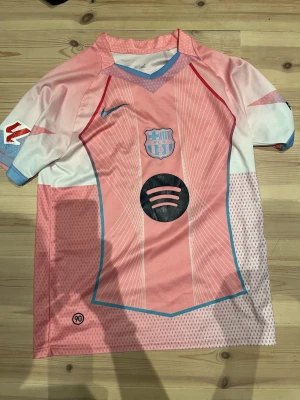 Sprillans ny lamine yamal tröja - Bilderna visar en rosa och vit FC Barcelona fotbollströja med namn och nummer på ryggen. Strl M