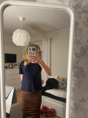 Brun långklänning i XS - Snygg brun långklänning i storlek XS med draperade detaljer längs sidan. Klänningen är ärmlös och har en mjuk, stretchig känsla i materialet. Perfekt för dig som gillar minimalistisk stil och jordnära färger.