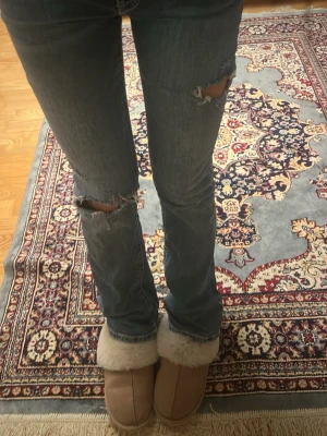 Blå bootcut jeans med slitningar - Säljer för jag använder dem inte, skräddare gjort hållen !! Passar för mig som har måttet 25/30. Jag är 164 cm. Pris kan diskuteras 