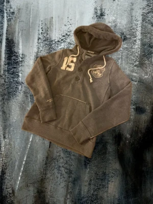 American spirit vintage hoodie - Snygg grå vit american spirit hoodie med många olika snygga feta detaljer skulle säga att den passar perfekt folk som är 175-185 det är storlek m skriv privat om ni vill se en bild med den på.