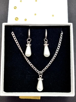 Halsband och örhängen  - Stilrena örhängen och halsband inspirerade av Maria Nilsdotter. Material-rostfritt stål. Örhängen längd-3,7cm, halsband längd-40cm. ☝️Vid köp ingår två extra berlocker som kan bytas ut, då själva hänget är ömtåligt och känsligt för stötar.