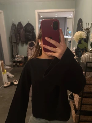 Svart långärmad topp Gina Tricot XS - Säljer en svart långärmad topp från Gina Tricot i storlek XS. Toppen har en rak, loose passform med vida ärmar och enkel design utan mönster eller detaljer. Perfekt att styla med jeans eller kjol för en clean look.