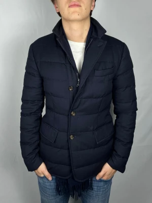 Moncler Down Blazer - Size: 2 (S) Skick: 7.5/10, väldigt bra overall men med en fläck. Retail pris: 10.000 SEK (+). Modellen är 185cm och väger 78kg. Hör av dig vid frågor eller funderingar!