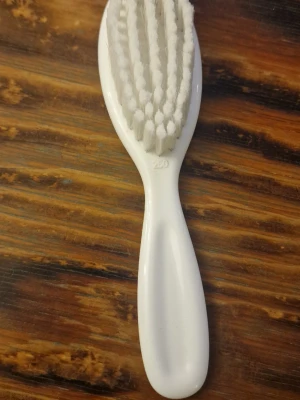 Vit hårborste för bebisar - Hårborste med vitt plastgrepp och täta, mjuka vita borststrån. Sparsamt använd.