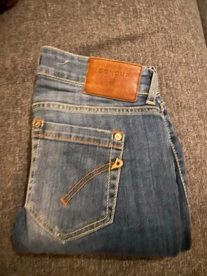 Blå Dondup jeans slim fit - Snygga blå jeans från dondup. Köpte för 1500 på Plick darför lite dyrare annons. Inga skador eller tecken på användning. Priset är absolut inte hugget i sten. Hör av er vid frågor😃