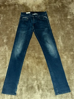 Replay Anbass jeans blå - Säljer ett par snygga Replay Anbass jeans i klassisk blå tvätt med lätt slitning! Jeansen är sparsamt använda, därav priset! Jeansen är tillverkade i mjukt denim-material med stretch för extra komfort.