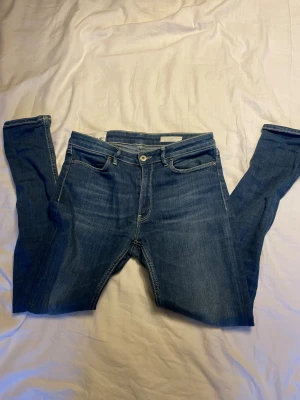 Dondup jeans - Snygga blå jeans från Dondup med klassisk femficksdesign och slim passform. Jeansen har en mörk tvätt med subtila slitningar och kontrastsömmar. Tillverkade i Italien i mjukt denimtyg som sitter tajt längs benen. Ny pris runt 3000. Storlek 29