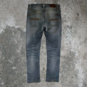 Grå/blå Grim tim’s - Tvärfeta Nudie Grim tim i färgen ”Org. twisted blue”. Tyget är 99% bomull, 1% elastan. Bra mycket honeycombing för att vara stretch. Har lagats två gånger nyligen hos Nudie så kan vara lite ”stiff” fortfarande i skrev, knän, osv. Storlek 32/34 men proffsigt uppsydda till ~32 (tyget är kvar så går lätt att sprätta up). Fadesen är väldigt gul/gråa och kontrastar fint med den ljusblåa färgen. Har fått mycket komplimanger av butiksarbetarna hos nudie! Lite av en intressekoll så här av er om pris osv