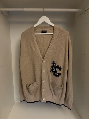 Beige cardigan från Lexington  - Riktigt snygg beige kofta från Lexington i storlek L. Koftan är ribbstickad med v-ringning, knappar framtill och två praktiska fickor. Om det finns frågor är det bara att skriva privat!
