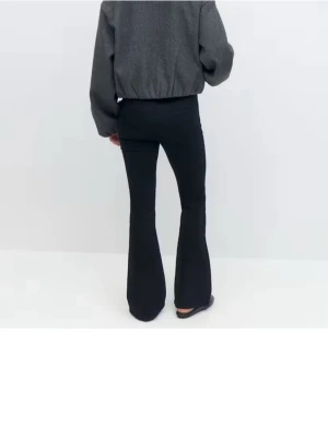 Svarta bootcut  - Säljer ett par svarta bootcut byxor med låg midja. Byxorna har en snygg utsvängd passform och sitter tajt upptill. Perfekta för dig som gillar en stilren och trendig look. Materialet är mjukt och stretchigt för extra komfort. Nytt skick 