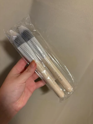 Hickap Kabuki borstar Limited Edition - Två sminkborstar från Hickap i limited edition: Round Kabuki 115 och Angled Kabuki 112. Borstarna har vita handtag, silverfärgade detaljer och täta, mjuka borst i svart och vitt. Perfekta för applicering av kräm och flytande sminkprodukter.