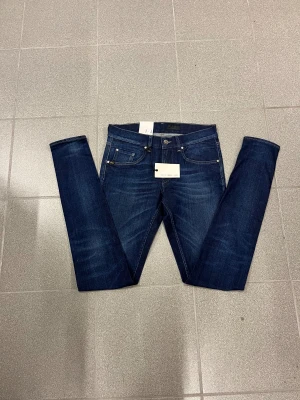 Mörkblå slimmade Tiger of sweden jeans herr W30 L34 - Snygga mörkblå slimmade jeans med smal passform och smala ben. Klassisk femficksmodell med silverfärgade nitar och läderpatch bak i midjan. Jeansen har en modern look och är tillverkade i slitstarkt denimtyg. Från T/J