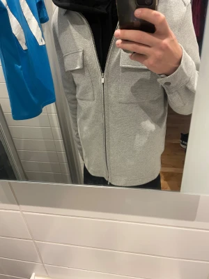 Grå overshirt med dragkedja - Grå  overshirt från dressman med två bröstfickor