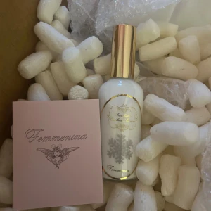 Femminina Snowflakes Cashmere Cream - Stilren parfym med vinterinspirerad design och lyxig känsla. Flaskan har gulddetaljer och snöflinga på etiketten. Perfekt för dig som vill sticka ut med något unikt och elegant.