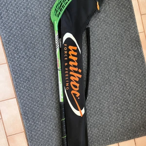 Innebandyklubba med väska - Fin innebandyklubba från unihoc med längd 80cm exklusive blad. Medföljer tillhörande väska. OBS! Finns ett överstruket namn på väskans lapp. Djur och rökfritt hem!