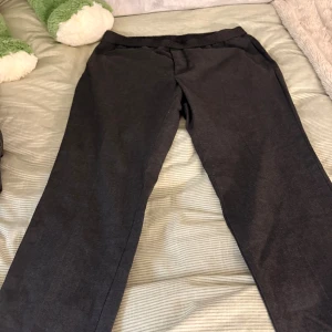 Svarta slim fit byxor från H&M - Svarta slim fit byxor från H&M med elastisk midja och snörning. Byxorna har en rak passform och är gjorda i mjukt material som känns skönt mot huden. Perfekta för dig som gillar en enkel och stilren look.