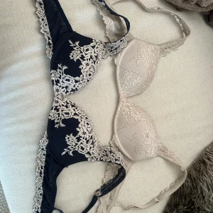Spets-bh:ar från Intimissimi - Två bh:ar från Intimissimi, en i marinblått med beige spets och en i helbeige spets. Båda har vackra blommiga spetsdetaljer och justerbara axelband. Noppriga inuti på banden men inget som synt utanpå, storlek 70B, 200kr för båda men de går att diskutera vid snabb affär 