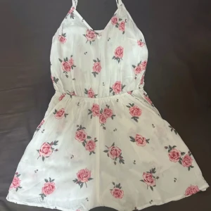 Vit blommig byxdress - Vit byxdress med rosa blommor, smala axelband och fickor