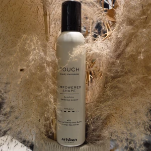 Touch Empowered Shape mousse - Touch Empowered Shape är en anti-frizz mousse från Artègo med olivblad, kornfröextrakt och druvskalsextrakt. Kommer i en beige flaska med svart lock och har en modern, stilren design. Perfekt för att forma och stärka håret.