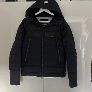 Sail racing vinterjackan  - Säljer nu min mörkblå sail racing jacka i storlek XS då den är för liten.Jackan har quiltad design, diskret logga på bröstet och huvan samt detaljer i mörkgrått ull över bröstet. Jackan har även två stora fickor framtill och två innerfickor. Den är fylld med 700 fill power dun från Allied Feather + Down. | Nypris 5000kr  Mitt pris 1500kr  Kom gärna med frågor 🙂