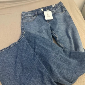Blå jeans Mira W 26 L 32 från Nudie - Snygga blå jeans från Nudie i modellen Mira, storlek W26 L32. Klassisk femficksdesign med raka ben och normal passform. Jeansen har en ljusblå tvätt och är tillverkade i slitstarkt bomullsjeansmaterial. Perfekta för en avslappnad och trendig look.