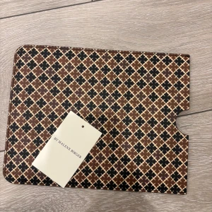 Brun Malene Birger - Stilren IPad fodral från By Malene Birger med ikoniskt grafiskt mönster i brunt, svart och beige. Aldrig använd ny pris 999kr🌸