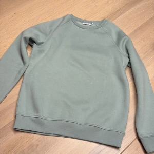 Mingrön sweatshirt från Name It - En stilren mintgrön (jättefin färg) sweatshirt från Name It i storlek 146-152. Tröjan har rund hals, ribbade muddar vid ärmslut och nederkant samt långärmad design. Perfekt för dig som gillar enkel och clean stil. Materialet är mjukt och skönt bomull/polyester.