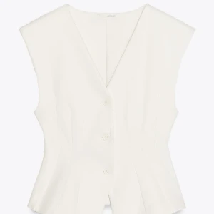 Vit figursydd väst med v-ringning - Snygg vit/beige väst med v-ringad hals och tre knappar framtill. Figursydd passform, i storlek L från Zara. Passar på mig som oftast har storlek S. Använt västen en gång, säljer då den tyvärr inte kommer till användning.🩵🩵