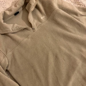 Beige fleece-tröja från Point Zero - Mysig beige fleece-tröja från Point Zero med half zip och hög krage. Tröjan har långa ärmar med resår vid handlederna och är perfekt för kyliga dagar. Enkel och stilren design som passar till allt.